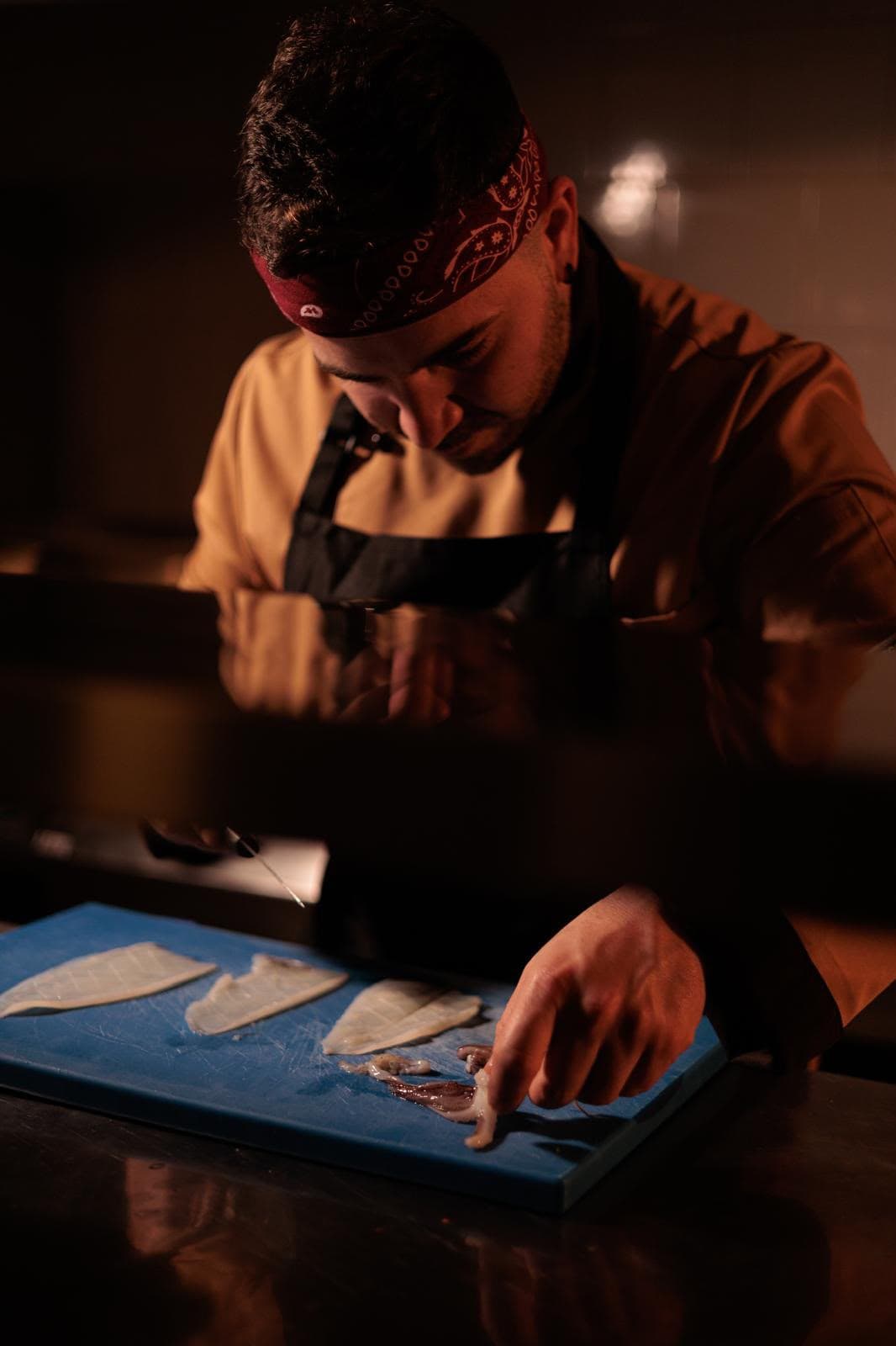 Aniello, chef di Osmosi, mentre prepara il pesce in cucina