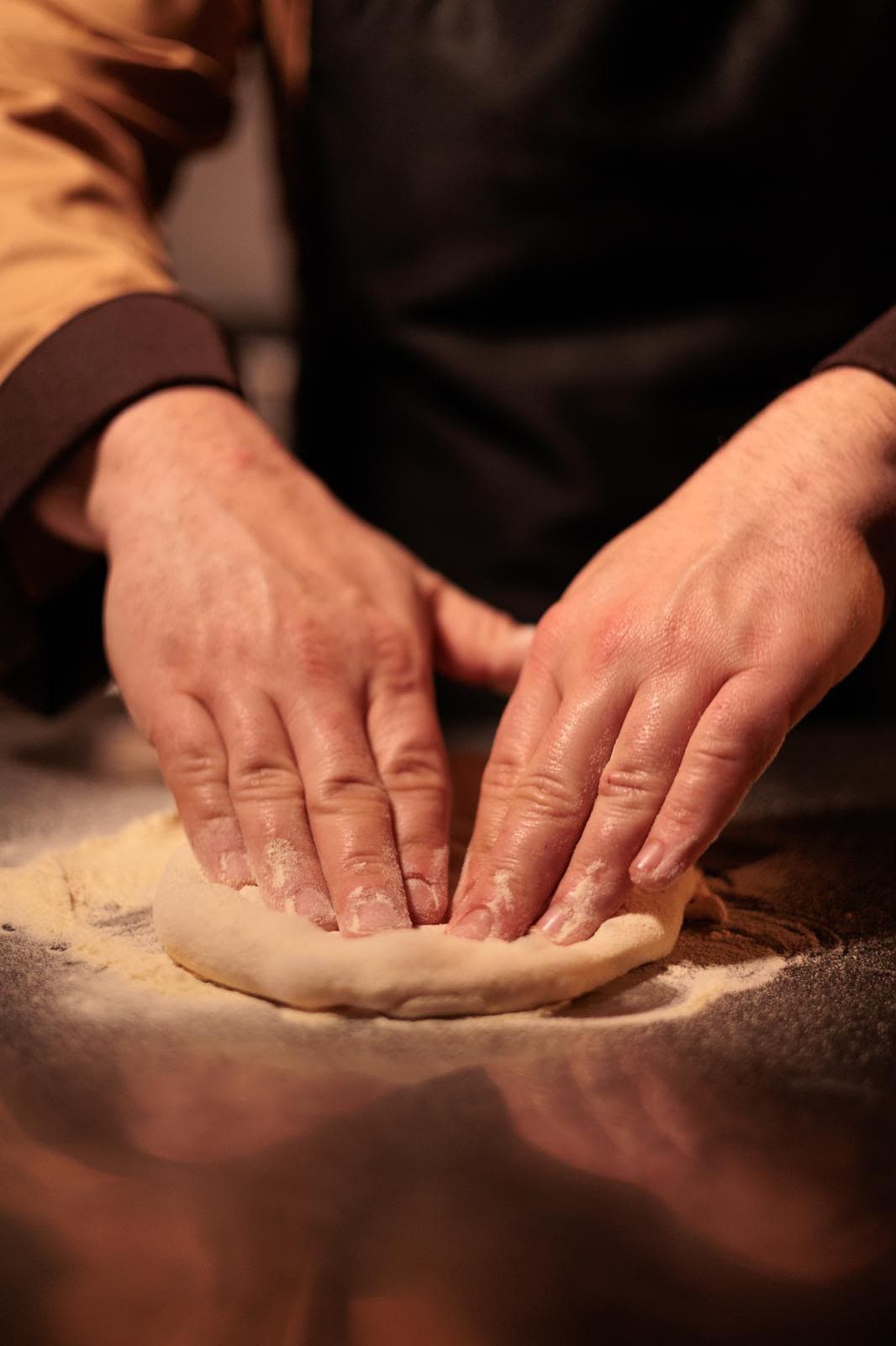 Mani dello chef che lavorano l'impasto