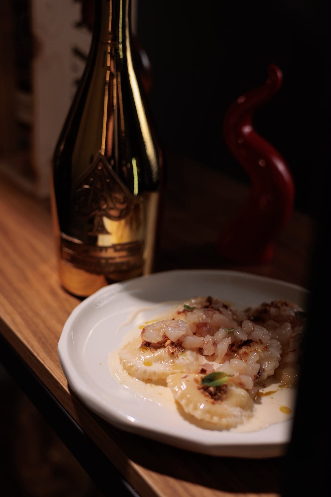 Ravioli con tartare di mare e bottiglia di champagne